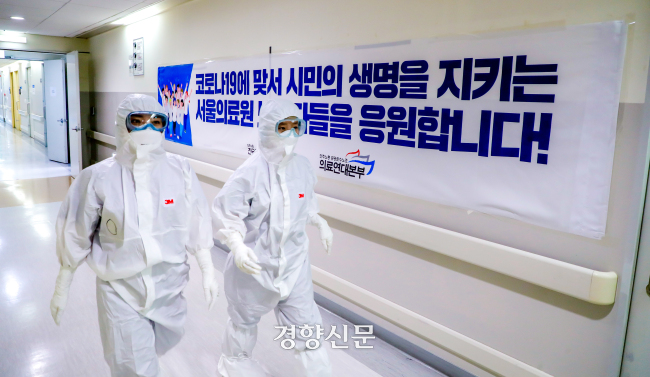 2020년 3월 코로나19 전담병원인 서울의료원 121병동의 과 유은희 간호사(왼쪽)와 이선숙 파트장이 지난 16일 레벨D방호복을 입고 환자가 있는 음압병실로 향하고 있다. 이석우 기자