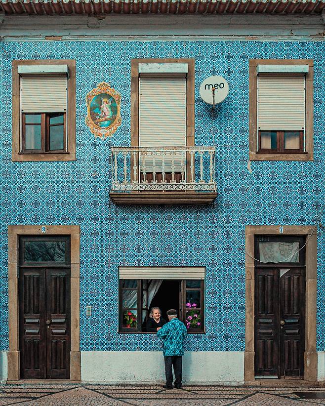 포르투갈 아베이루의 푸른 타일로 장식된 주택 ‘R. DR. 바르보자 드 마가야네스’. ‘포르투갈의 베네치아’로 불리는 이 항구도시 주민들은 평소에도 아래층 창을 열어두고 지나는 이들과 인사를 주고받는다. /웅진지식하우스
