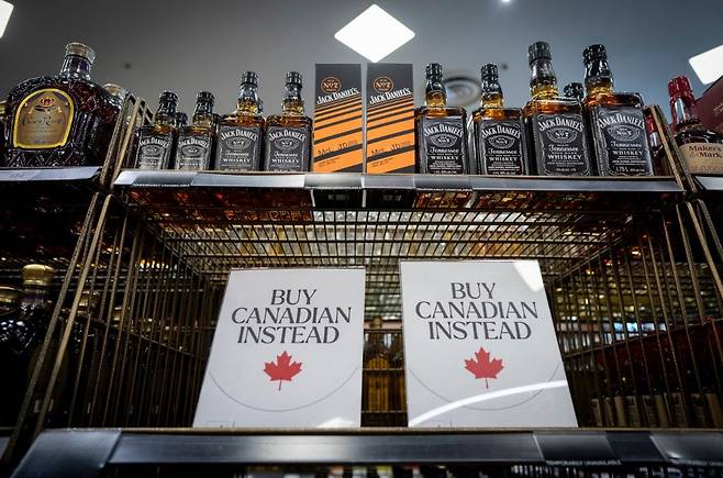 2025년 2월 2일 캐나다 밴쿠버의 한 주류 판매점에서 미국산 위스키 제품이 진열대에서 사라진 뒤 ‘대신 캐나다산을 사시오’라는 안내문이 놓여있다. AP 뉴시스