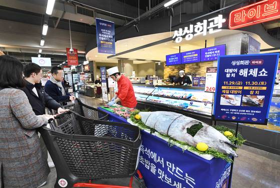 ‘홈플러스 메가 푸드 마켓 라이브’ 강서점이 지난해 11월 리뉴얼 오픈했다. 고객들이 멀티키친 ‘싱싱회관 라이브’ 앞에서 진행 중인 참치 해체쇼를 둘러보고 있다. 사진 홈플러스