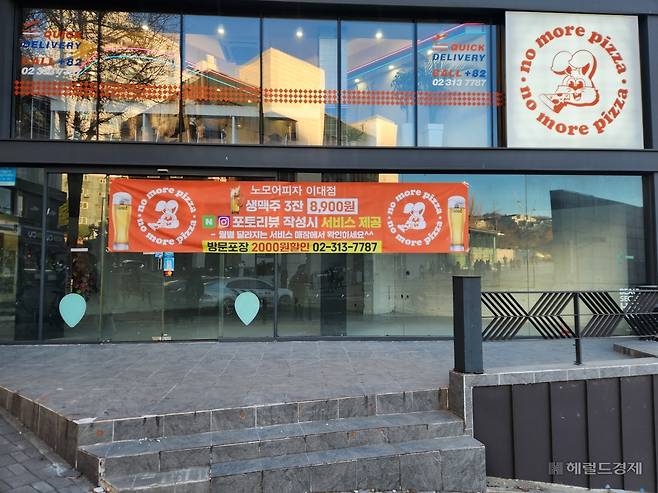 18일 이화여자대학교 정문 바로 앞 텅 빈 상가에 광고 현수막만 붙어있다. 이영기 기자.