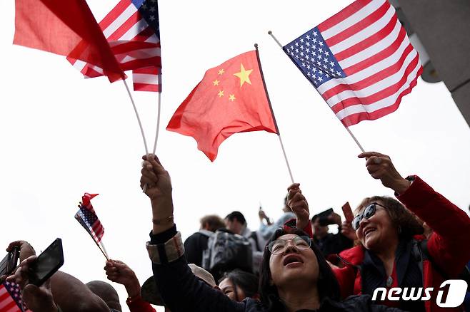 시진핑 중국 국가주석 지지자들이 오성홍기와 성조기를 들며 그의 미국 방문을 환영하고 있다. ⓒ 로이터=뉴스1