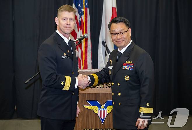 3일 부산 작전기지에 입항한 미국 핵 추진 항공모함 '칼빈슨함'(CVN-70) 격납고에서 미카엘 워지(준장) 제1항모강습단장, 이남규(준장) 해군작전사령부 해양작전본부장이 악수를 하고 있다. 2025.3.3/뉴스1 ⓒ News1 사진공동취재단