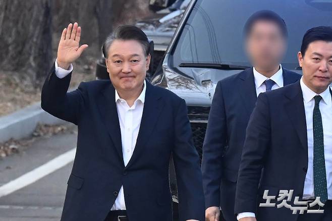 법원의 구속 취소 결정에 검찰이 항고를 포기하면서 석방된 윤석열 대통령이 8일 오후 경기 의왕 서울구치소에서 나와 지지자들에게 인사를 하고 있다. 오른쪽은 김성훈 경호처 차장. 의왕=황진환 기자