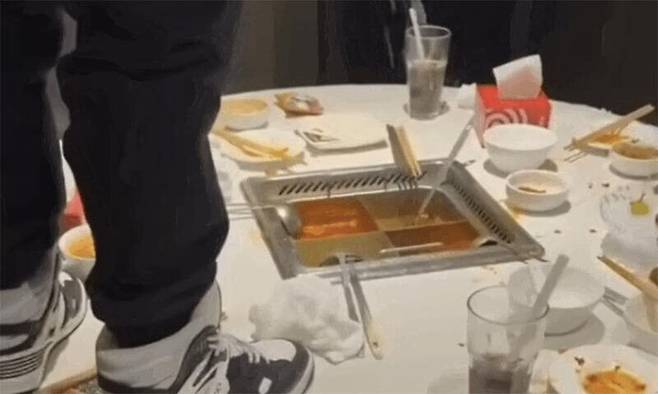 한 남성이 지난달 24일 중국 상하이시의 한 하이디라오 매장에서 훠궈 냄비에 소변을 보고 있다. 웨이보 캡처