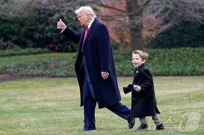 도널드 트럼프 미국 대통령(왼쪽)과 일론 머스크 테슬라 최고경영자(CEO)의 아들 애쉬 에이-트웰브 머스크(4)가 14일(현지시간) 미국 워싱턴DC 백악관에서 마린원으로 걸어가고 있다. 2025.03.14 ⓒ 로이터=뉴스1 ⓒ News1 정지윤 기자