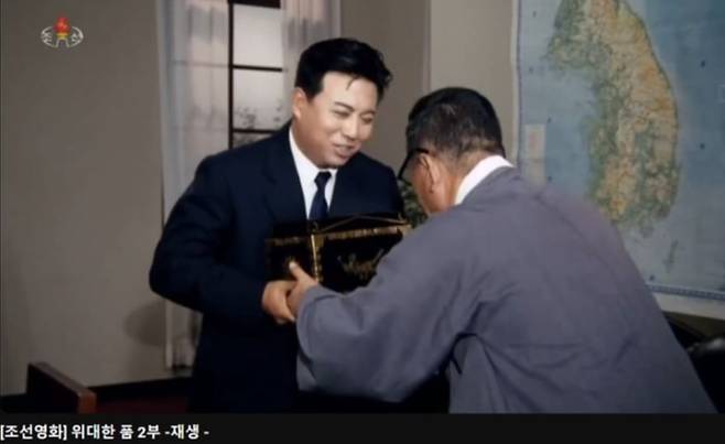 1986년 김정일의 지시로 북한에서 제작된 영화 ‘위대한 품’의 한 장면. 김구가 김일성에게 임시정부 인장을 바치려 했지만 김일성이 사양했다는 일화가 등장한다. /유튜브 캡처