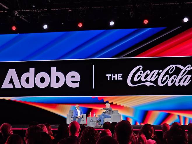 제임스 퀸시 코카콜라 회장 겸 최고경영자(CEO, 오른쪽)이 18일(현지시각) 미국 라스베이거스에서 열린 ‘어도비 서밋(Adobe Summit) 2025)’에서 샨타누 나라옌 어도비 CEO(왼쪽)와 함께 AI가 광고·마케팅 전략을 어떻게 변화시키고 있는지 논의하고 있다./사진=이경탁 기자