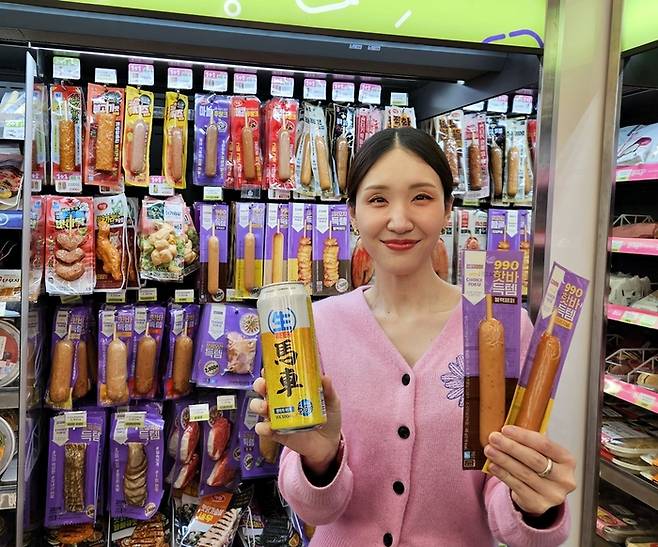 모델이 CU가 득템시리즈로 선보이는 990원 핫바, 1900원 맥주를 소개하고 있다.