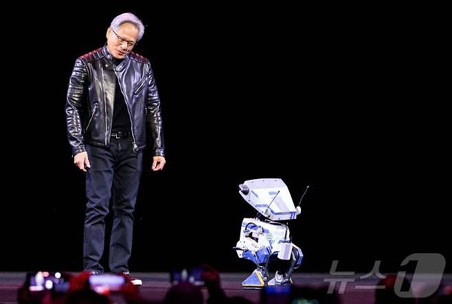 18일(현지시간) 미국 캘리포니아 새너제이 SAP 센터에서 열린 기조연설 세션에서 엔비디아 CEO 젠슨 황이 로봇과 대화를 나누고 있다. /AFPBBNews=뉴스1