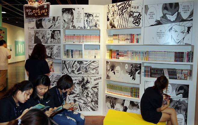 김해 '만화·애니메이션 축제'에서 만화책을 보고 있는 관람객들. 연합뉴스