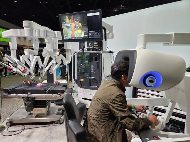 20일(현지시간) 미국 캘리포니아주 새너제이에서 열린 연례 개발자 컨퍼런스 'GTC 2025'에서 한 참가자가 수술 로봇 제조사 인튜이티브의 수술 로봇을 시연해보고 있다. 사진 박준이 기자