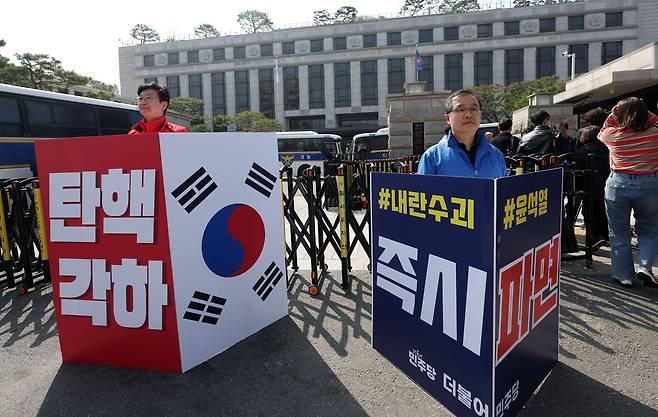 23일 서울 종로구 헌법재판소 앞에서 국민의힘 손범규(왼쪽) 인천 남동구갑 당협위원장과 더불어민주당 이건태 의원이 각각 탄핵 각하와 즉시 파면을 촉구하며 1인 시위를 하고 있다. /뉴시스