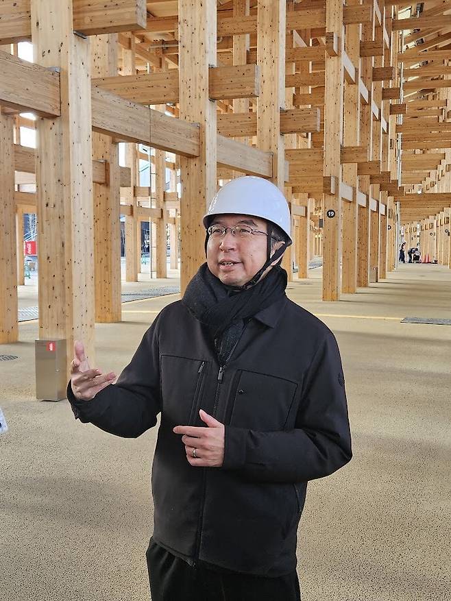 후지모토 소우 소장이 오사카 엑스포 현장에 지어진 그랜드 링의 건축공법에 대해 설명하고 있다.