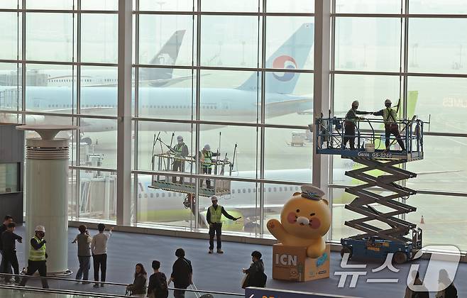 인천공항운영서비스 환경미화운영그룹 직원들이 25일 오전 인천국제공항 제2터미널에서 봄맞이 유리창 물청소를 하고 있다. 2025.3.25/뉴스1 ⓒ News1 장수영 기자