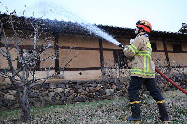 25일 경북 안동 하회마을에서 소방관이 산불에 대비해 물을 뿌리고 있다. /연합뉴스