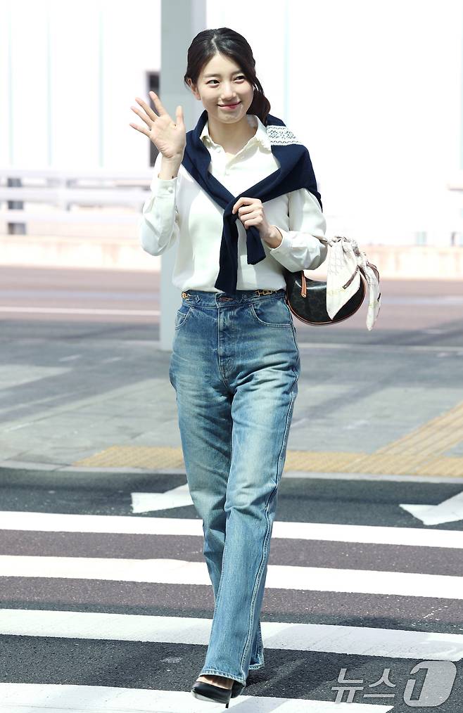 배우 수지가 해외 일정을 위해 26일 인천국제공항을 통해 싱가포르로 출국하며 환호하는 팬들에게 손을 흔들고 있다. ⓒ News1 권현진 기자