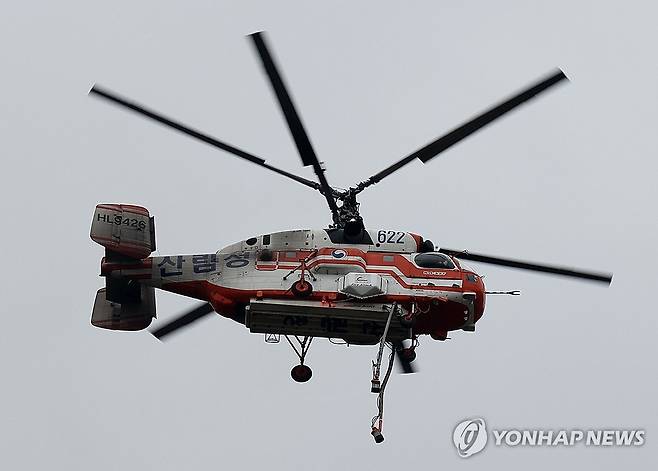 검게 그을린 산림청 헬기 (울산=연합뉴스) 김용태 기자 = 27일 엿새째 산불이 이어지고 있는 울산시 울주군 온양읍에서 진화 작업을 하는 산림청 헬기가 검게 그을려 있다. 2025.3.27 yongtae@yna.co.kr