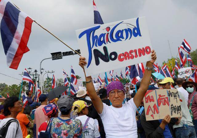 27일 태국 방콕 정부청사 앞에서 정부의 카지노 합법화 추진을 반대하는 시위대가 팻말을 들고 있다. 방콕=EPA 연합뉴스