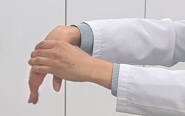 손등을 당겨 풀어주는 스트레칭 동작.