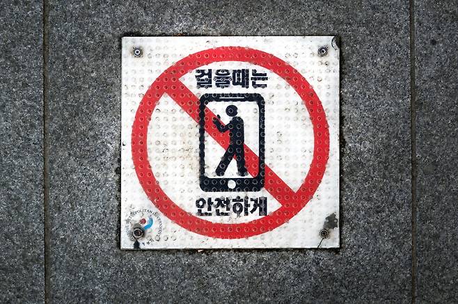 광화문 거리를 걷다 보니 이러한 문구가 적힌 표지판이 바닥에 붙어 있습니다. 스마트폰이 생활의 일부가 되면서 휴대전화를 보며 다니는 사람들이 많습니다. 거리를 다닐 때만이라도 서로의 안전을 위해 휴대전화를 잠시 주머니에 넣어두면 어떨까요. 이충우 기자