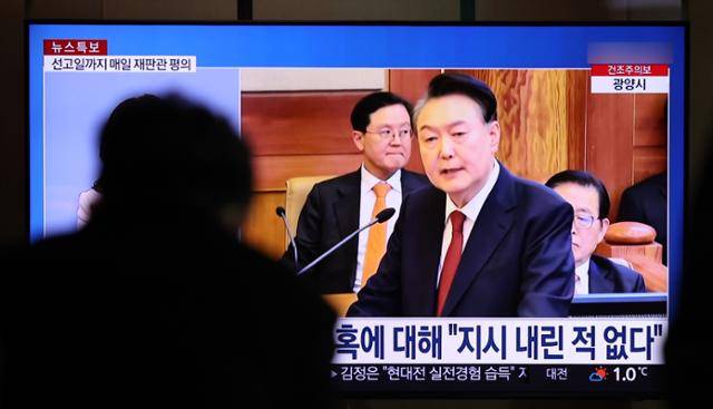 2월 26일 서울 용산구 서울역에서 시민들이 윤석열 대통령 탄핵심판 최종 변론 관련 뉴스를 시청하고 있다. 뉴시스