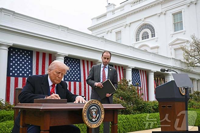 도널드 트럼프 미국 대통령이 2일(현지시간) 미국 워싱턴 D.C. 백악관 로즈가든에서 상호 관세 부과 방침을 전격 발표 후 행정명령서에 서명을 하고 있다. ⓒ AFP=뉴스1