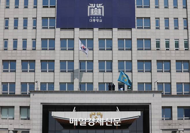 4일 서울 용산구 대통령실에 걸려있던 봉황기(왼쪽)가 헌법재판소의 윤석열 대통령 탄핵 인용 이후 대통령실 관계자들에 의해 내려지고 있다. <대통령실사진기자단>