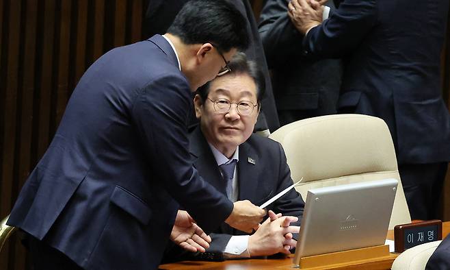 이재명 더불어민주당 대표가 지난 4일 서울 여의도 국회에서 열린 제424회 국회(임시회) 제1차 본회의에서 김우영 의원으로부터 종이봉투를 받고 있다. 뉴시스
