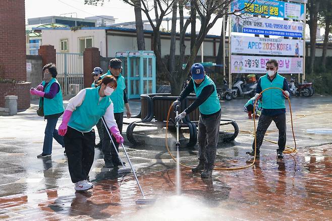 칠곡군 민간 환경봉사단체 ‘더 나은 칠곡’ 회원들이 고압세척기와 솔을 이용해 왜관역 광장 바닥을 청소하고 있다. 칠곡군 제공