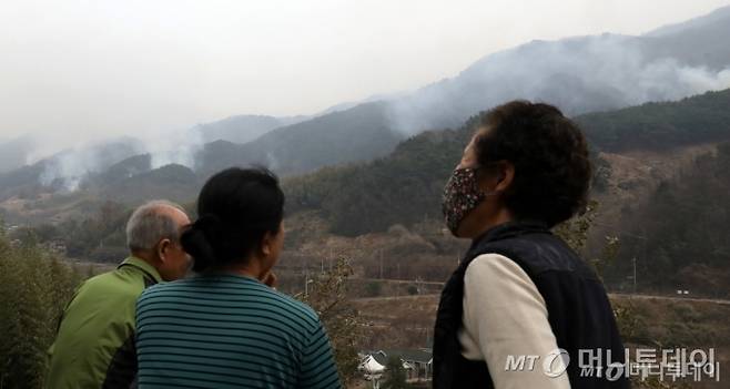 (산청=뉴스1) 윤일지 기자 = 경남 산청·하동 산불 일주일째인 27일 오후 주민들이 지리산과 인접한 산청군 시천면 동당마을 위로 피어오르는 산불 연기를 지켜보고 있다. 산청에는 오후부터 5mm 내외의 적은 비가 예보됐지만 현재 비는 내리지 않고 있다. 2025.3.27/뉴스1 Copyright (C) 뉴스1. All rights reserved. 무단 전재 및 재배포, AI학습 이용 금지. /사진=(산청=뉴스1) 윤일지 기자