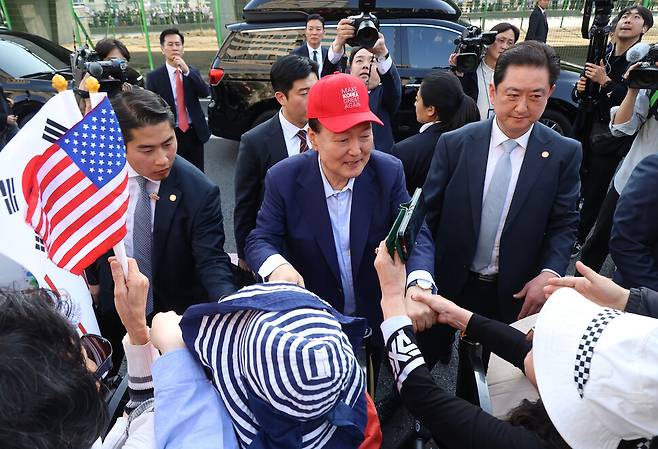 윤석열 전 대통령이 11일 서울 용산구 한남동 관저 앞에서 ‘Make Korea Great Again(다시 한국을 위대하게)’라고 적힌 빨간 모자를 쓰고 지지자들과 인사하고 있다. 공동취재사진