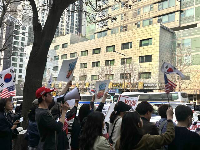 11일 윤석열 전 대통령이 서초구 서초동 아크로비스타 사저에 복귀한 직후 맞은편 인도에 몰려든 지지자들이 구호를 외치고 있다. 장형임기자