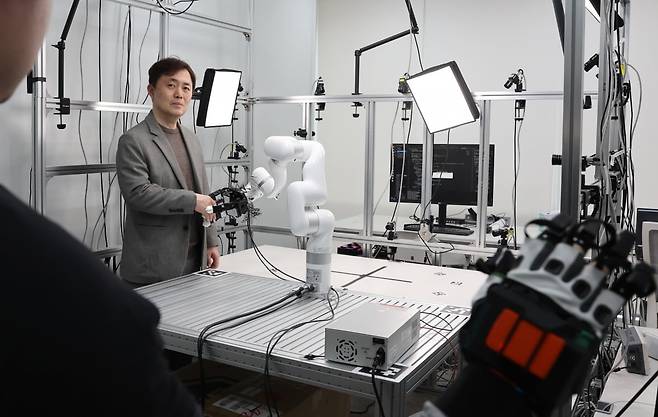 서울대 컴퓨터연구소 패러덱스 설비 공간에서 서진욱 서울대 컴퓨터연구소장이 로봇 손과 악수하고 있다. / 사진=이솔 기자