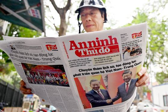 14일 베트남을 국빈방문하는 시진핑 중국 국가주석과 토람 베트남공산당 총서기 관련 기사가 실린 신문을 하노이 시민이 읽고 있다. AFP=연합뉴스
