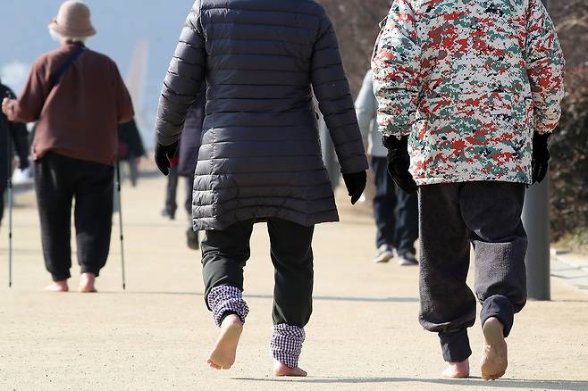 대구 수성못을 찾은 시민들이 산책로를 따라 맨발로 걷고 있다. /뉴스1