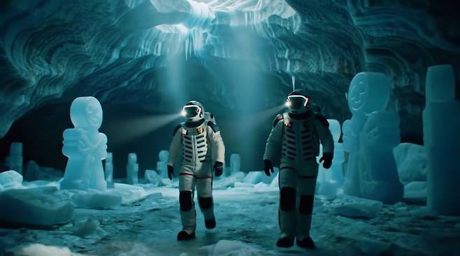 구글이 15일 출시한 영상 생성 인공지능(AI) 모델 '비오 2'에 '광각의 느린 패닝 샷으로 으스스한 황혼에 휩싸인 거대한 빙하 동굴에서 창백한 청록색 빛이 위에서부터 내려와 얼음 벽 안에 있는 얼어붙은 사탕 모양의 형상을 비추는 가운데 흰색 외피를 입은 두 명의 인물이 헬멧의 빛을 발산하며 중앙을 통과한다'는 프롬프트를 입력해 생성한 영상의 한 장면./ 구글 제공