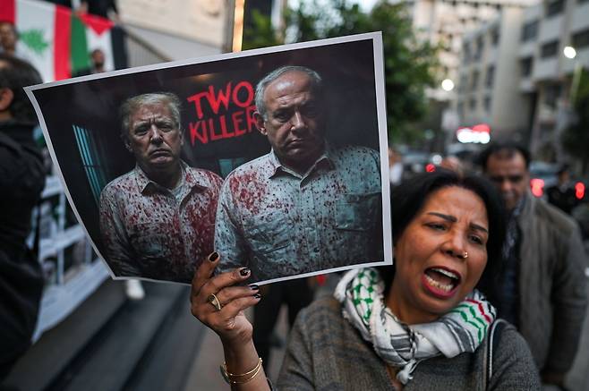 15일 이집트 카이로에서 팔레스타인 가자지구 전쟁에 반대하는 사위 참가자가 도널드 트럼프 미국 대통령(왼쪽)과 베냐민 네타냐후 이스라엘 총리(오른쪽)을 비판하는 손팻말을 들고 행진하고 있다. EPA연합뉴스