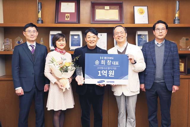 송희창(왼쪽 세 번째) 씨가 지난 2023년 수술비가 없어 치료를 받지 못하는 소아·청소년 환아 지원을 위해 삼성서울병원에 1억 원을 기부하고 난 뒤 기념사진을 찍고 있다. 초록우산 제공