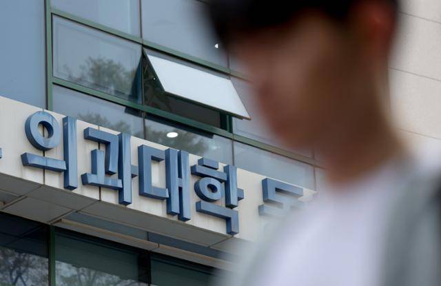 한 학생이 지난 16일 서울 시내의 한 의대 건물 앞을 지나가고 있다. 정부는 2026학년도 의대 모집인원을 3,058명으로 결정해 발표했다. 뉴시스