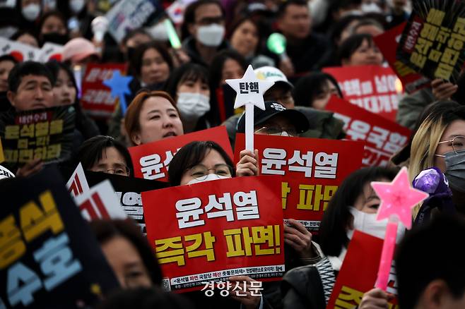 지난달15일 서울 광화문 동십자각 앞에서 윤석열 즉각퇴진·사회대개혁 비상행동 주최로 열린 15차 범시민대행진에서 참석자들이 윤석열 전 대통령 탄핵을 촉구하며 구호를 외치고 있다. 성동훈 기자