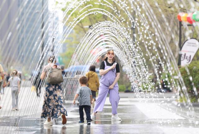 17일 서울 종로구 광화문광장에서 외국인 관광객이 물놀이를 하고 있다. 연합뉴스