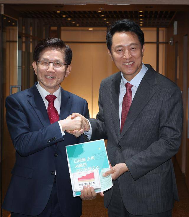 오세훈 서울시장과 회동을 마친 김문수(왼쪽) 전 고용노동부 장관이 16일 서울시청 시장실을 나서며 배웅 나온 오 시장과 악수하고 있다. 연합뉴스