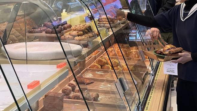 ‘그린 플레이트’를 이용하고 있는 한 고객의 모습. 녹색 접시에 원하는 빵을 담고 계산대에서 결제한 후 취식하면 된다. 윤우열 기자 cloudancer@donga.com