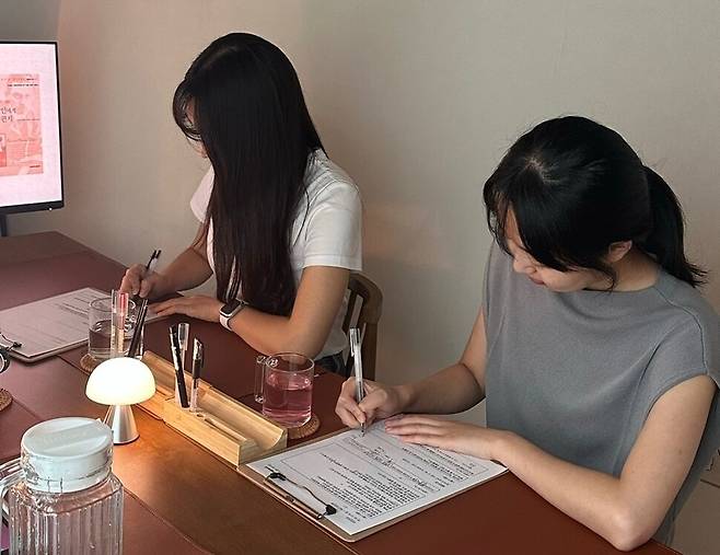 오프라인 필사 모임에 참여해 함께 필사하는 20대 여성. 필사 모임에 참여하는 이들은 대부분 여성이다. ‘인팩트’ 제공