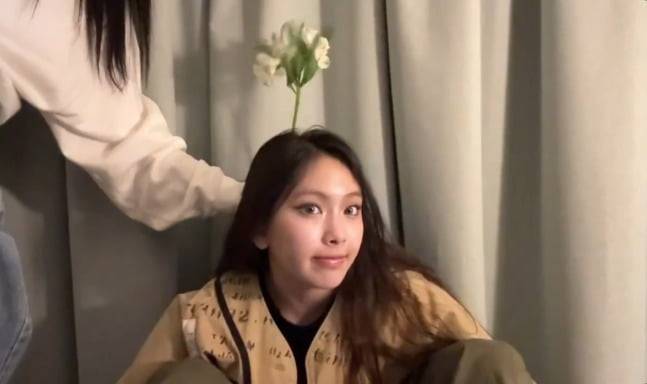 피크민 게임을 즐기는 뉴진스 멤버 혜인. 머리에 꽃이 자라난 듯한 '피크민샷' 포즈를 취하고 있다. /사진=뉴진스 라이브 방송 캡처