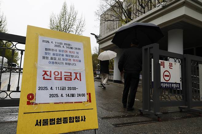 <누구를 위한 통제인가> 12·3 비상계엄을 선포해 내란 우두머리 혐의로 기소된 윤석열 전 대통령의 첫 정식 형사재판을 하루 앞둔 13일 서울중앙지방법원 청사 입구에 출입통제 안내문이 붙어 있다. 문재원 기자