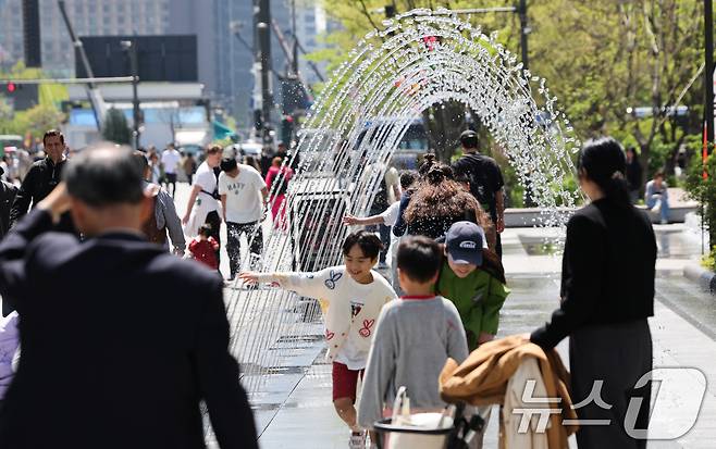 봄철 마지막 절기 곡우(穀雨)인 20일 서울 광화문광장에서 시민과 관광객들이 분수터널을 지나고 있다. .2025.4.20/뉴스1 ⓒ News1 허경 기자