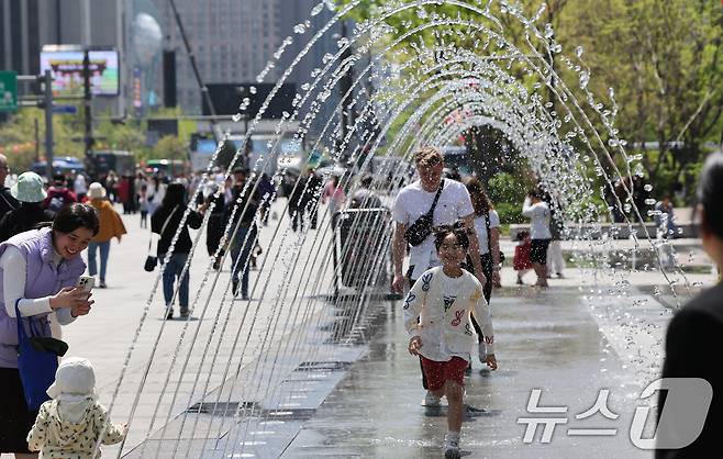 봄철 마지막 절기 곡우(穀雨)인 20일 서울 광화문광장에서 시민과 관광객들이 분수터널을 지나고 있다. 2025.4.20/뉴스1 ⓒ News1 허경 기자