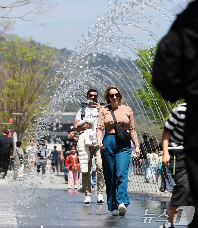 봄철 마지막 절기 곡우(穀雨)인 20일 서울 광화문광장에서 시민과 관광객들이 분수터널을 지나고 있다. .2025.4.20/뉴스1 ⓒ News1 허경 기자